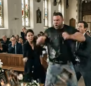 Un mormorio di stupore si diffuse nella sala funebre quando un motociclista rovesciò improvvisamente il tavolo commemorativo di uno studente, facendo cadere candele e foto mentre urlava: “Indietro, subito!”. Ma cosa aveva notato?